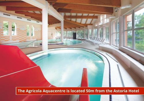 an indoor hot tub in a building with chairs at Hotel Astoria in Jáchymov