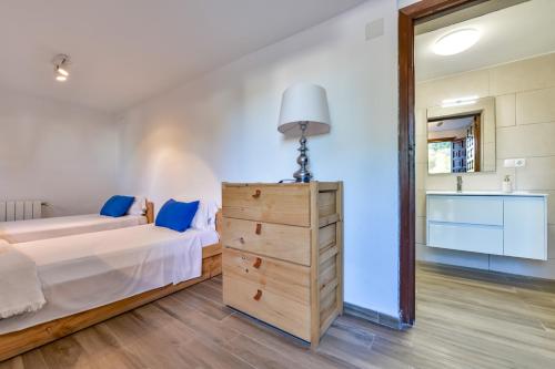 een slaapkamer met een bed en een dressoir met een lamp bij Villas Guzman - Olga in Moraira