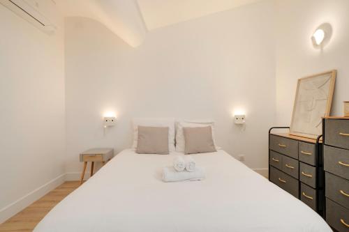 - une chambre avec un grand lit blanc et une commode dans l'établissement Le Cocon de Jeanne - Nancy Thermal - 2 Pers, à Nancy