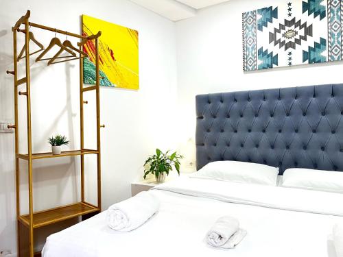 a bedroom with a bed with a blue headboard at Tirana Square Hotel in Tirana