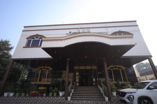 a building with a car parked in front of it at Hotel Sheetal Regency,Near Janambhumi in Mathura