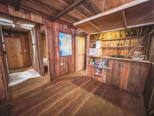 a room with wooden walls and a kitchen with wooden floors at Alojamiento frente al mar playa la barra in Buenaventura