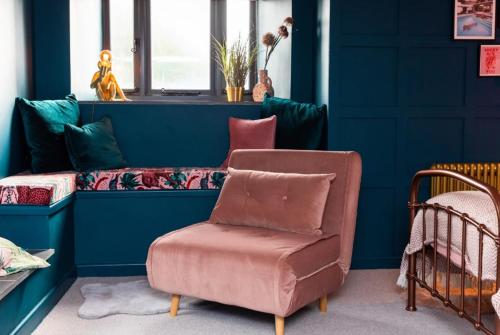 a blue room with a chair and a couch at The West Wing in Barnstaple