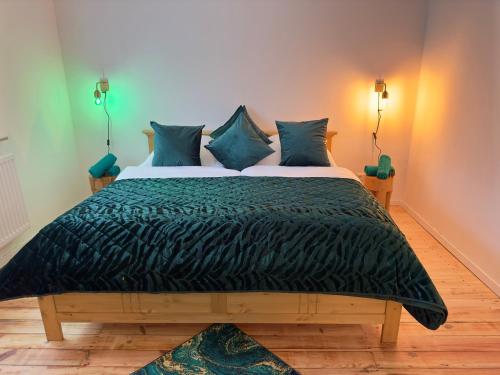 a bedroom with a large bed with green comforter at Möbliert-nahe STARLIGHT EXPRESS in Bochum -WLAN-Netflix-Loggia oder Terrasse in Bochum
