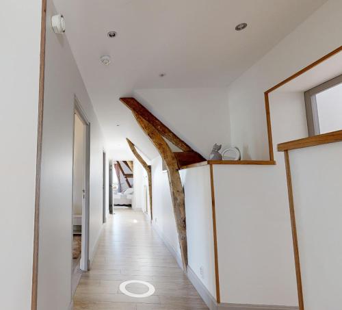 a hallway in a house with white walls and wooden floors at Chambre double Paradis in Ferrières-la-Verrerie