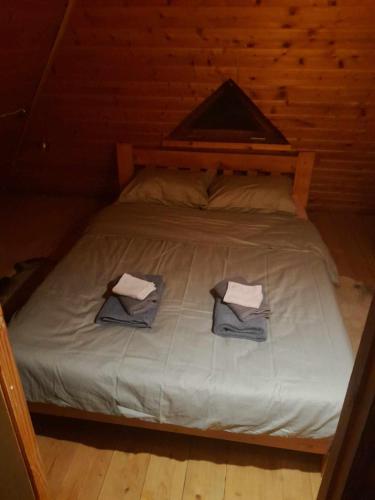 a bed with two towels on it in a cabin at Kikepera Alamaja in Parnumaa