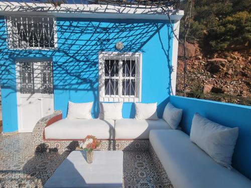a blue house with a couch and a window at Ourika Valley Haven - Breathe, Relax, Unwind in Ourika