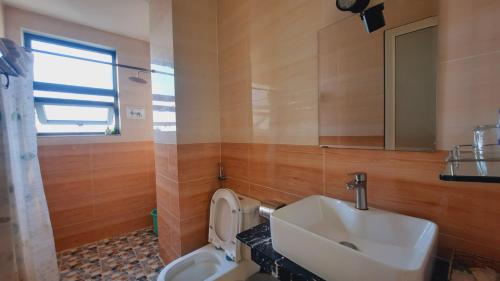 a bathroom with a sink and a toilet and a mirror at NEST House in Ấp Kim Thạch