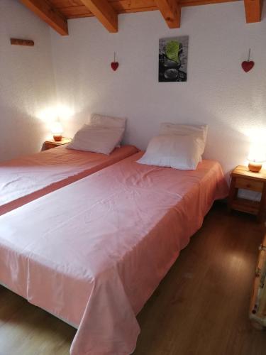 deux lits jumeaux dans une chambre avec deux lampes dans l'établissement Appartement 11 personnes, à Saint-Martin-de-Belleville