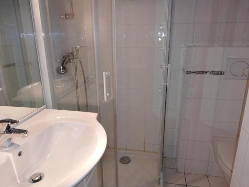 une salle de bain avec un lavabo et une douche dans l'établissement Appartement 11 personnes, à Saint-Martin-de-Belleville