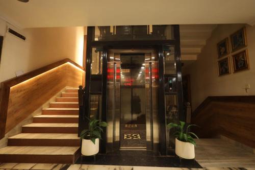 an elevator in a building with two potted plants at Hotel Sheetal Regency,Near Janambhumi in Mathura