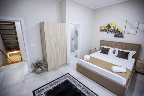 a bedroom with a large bed and a bathroom at EKA Luxury Seaview Apartments in Vlorë