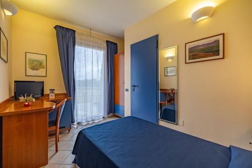 a bedroom with a blue bed and a desk and a computer at 1000 Miglia in Monteroni dʼArbia