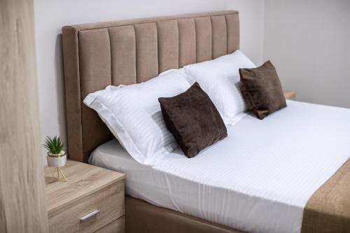 a bed with two pillows on it in a room at EKA Luxury Seaview Apartments in Vlorë