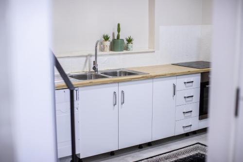 a kitchen with white cabinets and a sink at EKA Luxury Seaview Apartments in Vlorë