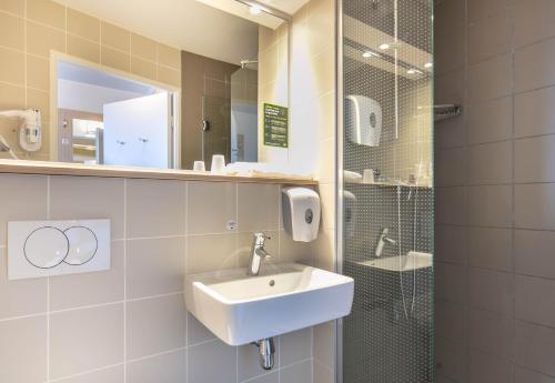 a bathroom with a sink and a shower at B&B HOTEL Lyon Aéroport Saint-Quentin-Fallavier in Saint-Quentin-Fallavier
