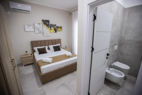 a bedroom with a bed and a bathroom with a toilet at EKA Luxury Seaview Apartments in Vlorë