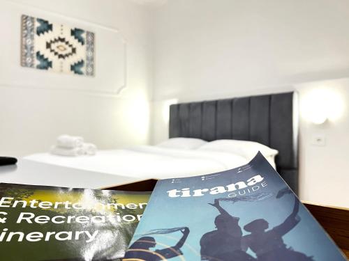 a room with a bed and a magazine on a table at Tirana Square Hotel in Tirana