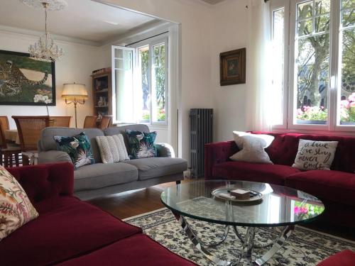 a living room with red couches and a glass table at Luxurious Townhouse 10 mins walk to Epernay centre in Épernay