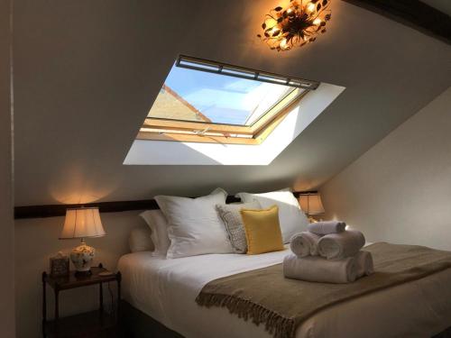 a bedroom with a large bed with a skylight at Luxurious Townhouse 10 mins walk to Epernay centre in Épernay