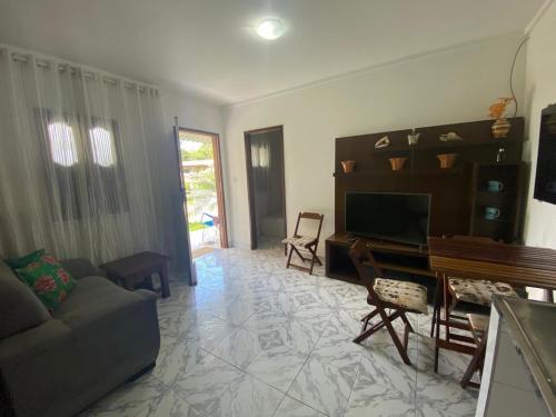 Casa ilha de Itaparica Aratuba 3 في Aratuba Beach: غرفة معيشة مع أريكة وتلفزيون