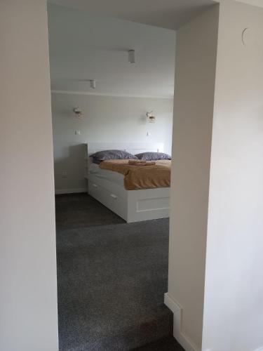 a bedroom with a bed in a white room at Ośrodek Wypoczynkowy Świerkocin in Świerkocin