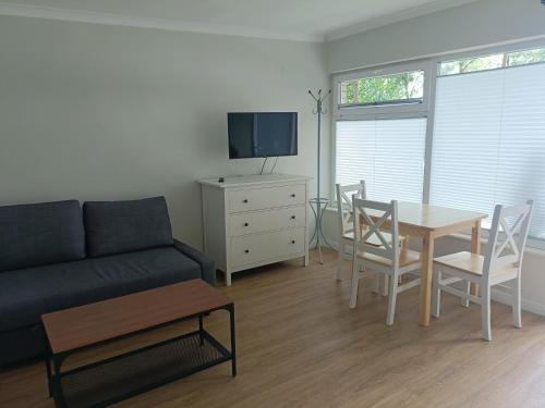 a living room with a couch and a table with chairs at Ośrodek Wypoczynkowy Świerkocin in Świerkocin