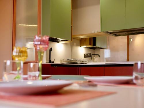une cuisine avec des placards verts et des plaques blanches sur une table dans l'établissement Biarritz, Halles et Océan, à Biarritz