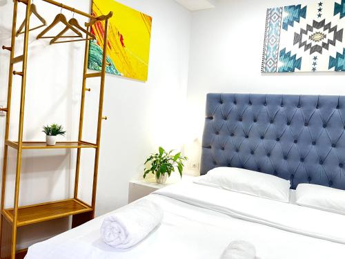 a bedroom with a bed with a blue headboard at Tirana Square Hotel in Tirana