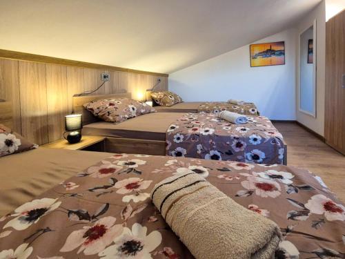 a hotel room with two beds with flowers on them at Bijeg u mir, Dvosobni apartman in Pula