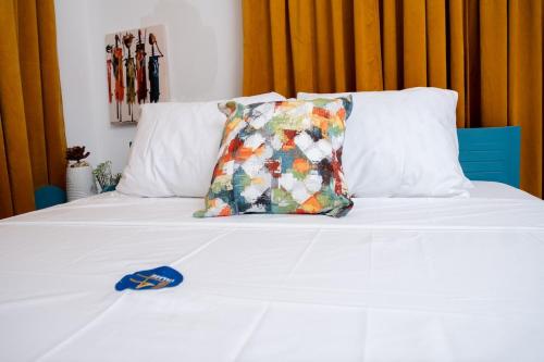 a white bed with a pillow on top of it at Ultimate Relaxation at H Village in Dawhwenya