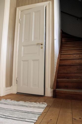 a white door in a hallway with a rug at Norrqvarn Hotel & Resort by Vänerport in Lyrestad