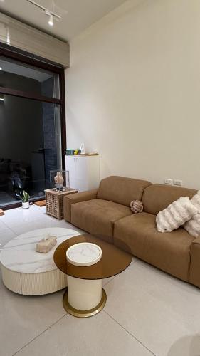 a living room with a brown couch and a table at 鹿港 尋鹿好旅 民宿 in Lugang