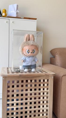 a doll in a glass box on a table at 鹿港 尋鹿好旅 民宿 in Lugang