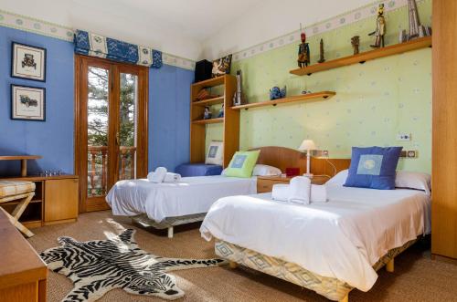a bedroom with two beds and a zebra rug at YourHouse Tramontana villa in Lloseta