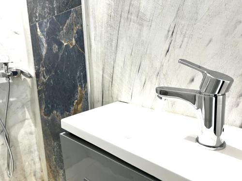 a bathroom with a white sink and a shower at Tirana Square Hotel in Tirana