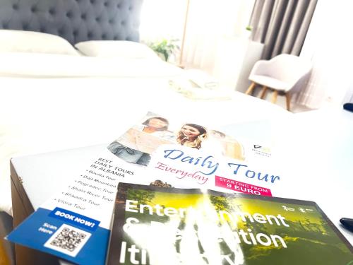 a pile of magazines sitting on top of a bed at Tirana Square Hotel in Tirana