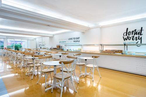 a dining room with tables and stools at Hotel Vibra Vila in Ibiza Town