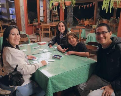 a group of people sitting around a green table at Huertalejandro Restaurante Campestre y Hospedaje in Cieneguilla