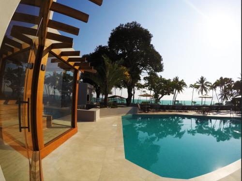 una piscina con vista sull'oceano di Apartamento Canto Sul - pé na areia a São Sebastião