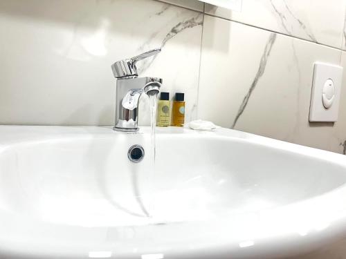 a bathroom sink with a faucet and a mirror at Tirana Square Hotel in Tirana