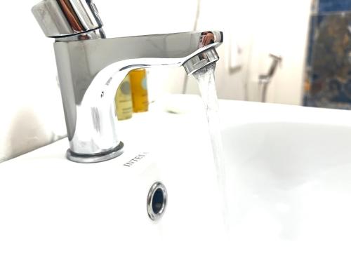 a bathroom sink with water running from a faucet at Tirana Square Hotel in Tirana