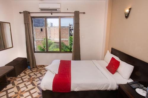 a bedroom with a large bed and a window at Aadarsha Inn Pvt Ltd in Lumbini