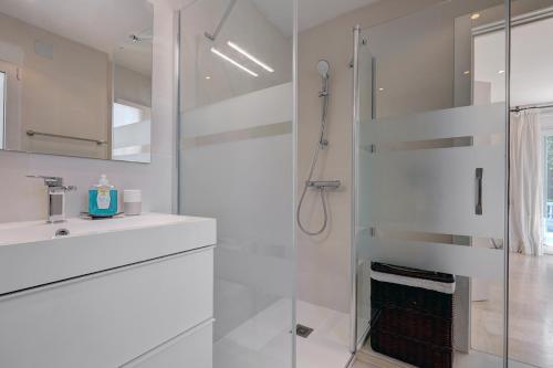 ein weißes Badezimmer mit Dusche und Waschbecken in der Unterkunft Private Villa, Heated Pool Puerto Banus Marbella in Marbella
