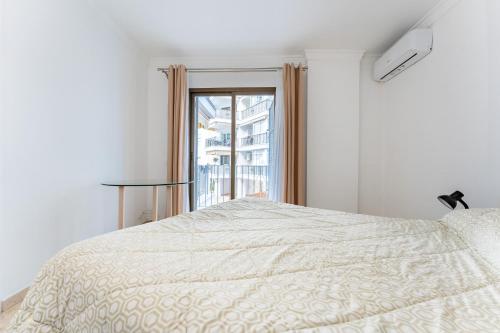 ein weißes Schlafzimmer mit einem Bett und einem Fenster in der Unterkunft CT 350 - Faro's Marbella Beachapartment - perfect beachconection in Marbella