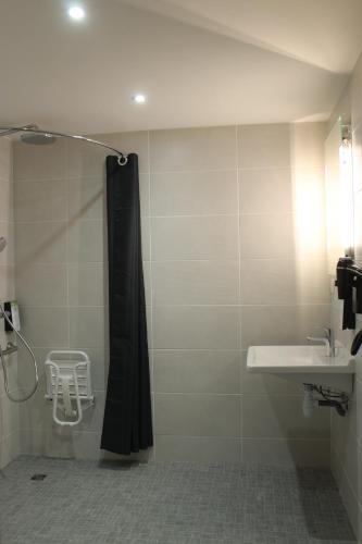 a bathroom with a shower curtain and a sink at Kyriad Anglet - Biarritz in Anglet