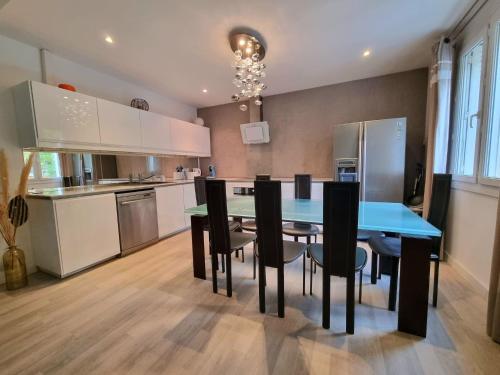 une cuisine avec une table bleue et des chaises noires dans l'établissement 1 avenue maurice blondel - T4 centre-ville, à Aix-en-Provence