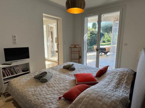 - une chambre avec un lit doté d'oreillers rouges dans l'établissement L'écrin au Super Lavandou, au Lavandou