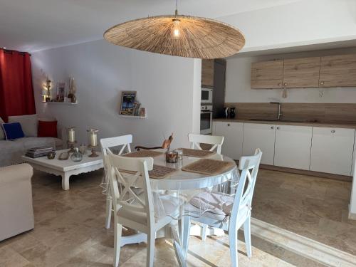 une cuisine et une salle à manger avec une table et des chaises dans l'établissement L'écrin au Super Lavandou, au Lavandou