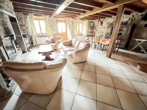 a large living room with couches and a table at Maison cosy à Lanobre + Jardin in Lanobre